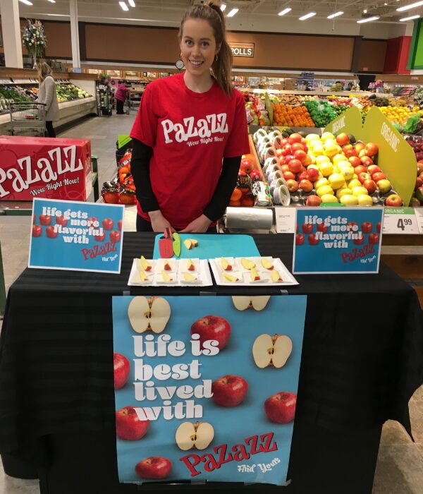 A woman standing in front of an apple display.